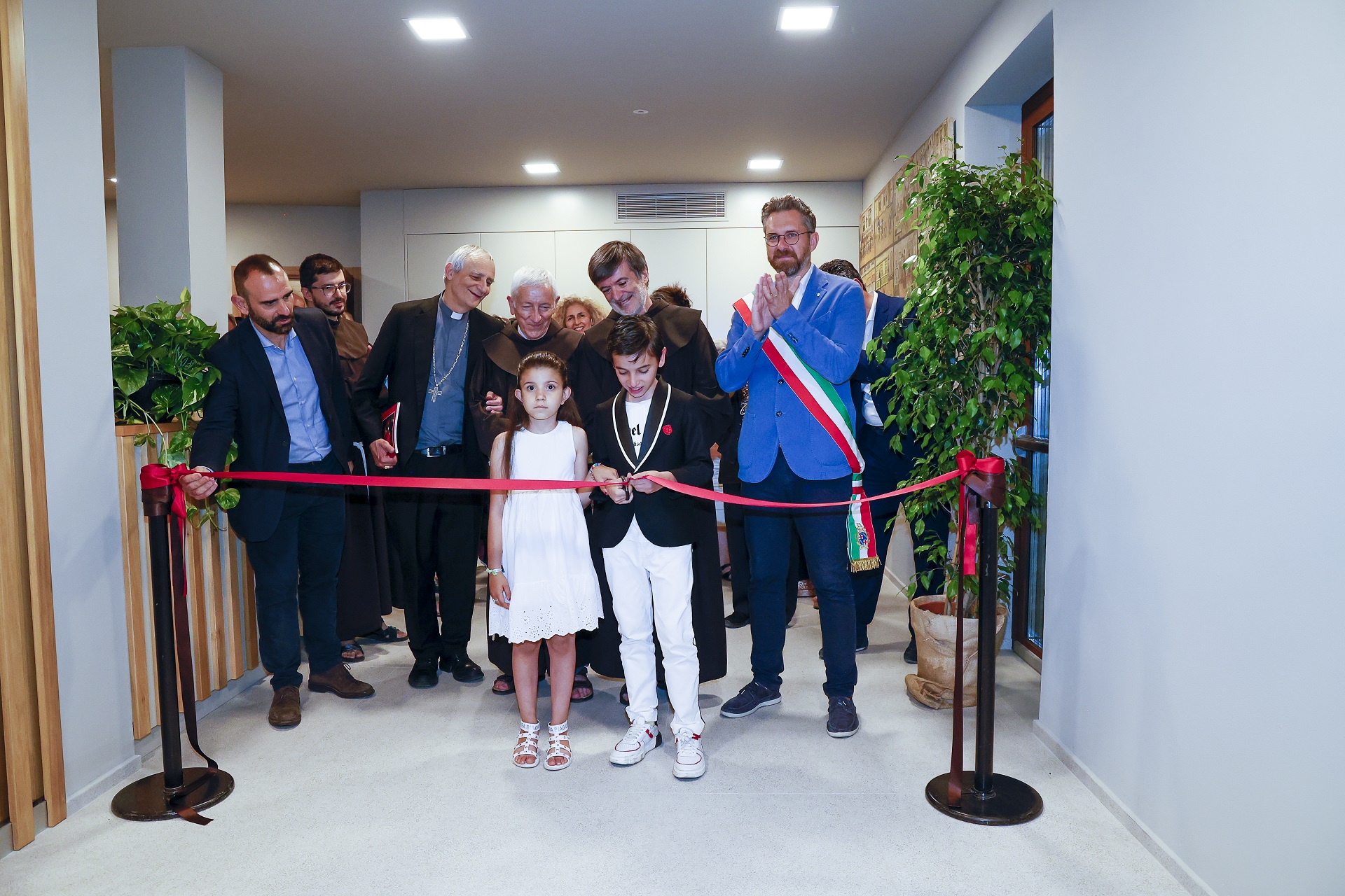 Il taglio del nastro, un attimo prima di entrare nella nuova mensa Fra Faustino con i bimbi ucraini accolti dal convento di Bordighera