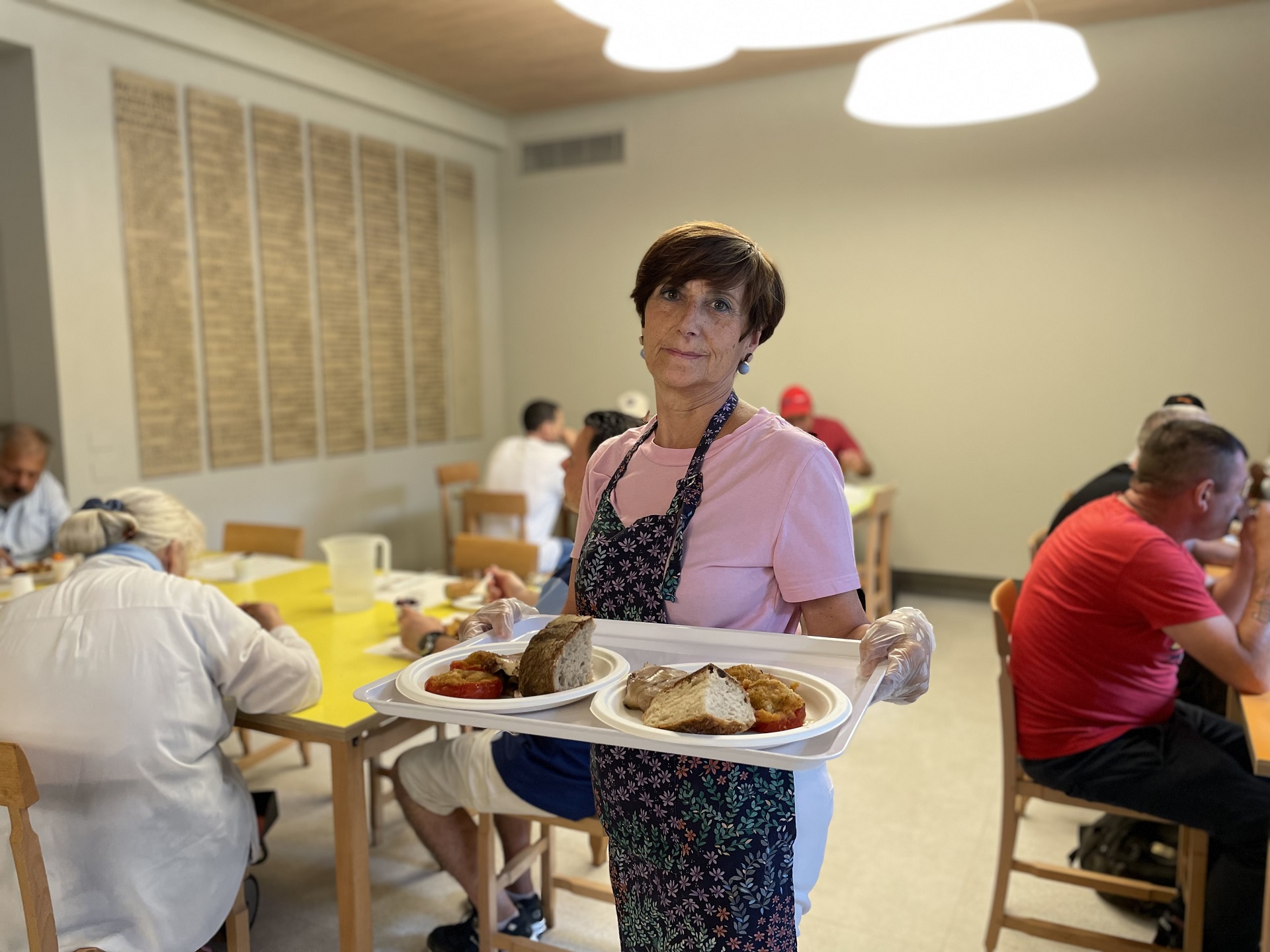 Una volontaria serve il pranzo in mensa Una volontaria serve il pranzo in mensa